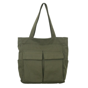 Front view of army green canvas tote bag with large front pockets for travel