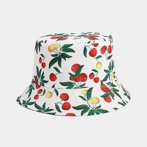 Detailed view of the cotton fabric texture and colorful cherry print on the bucket hat