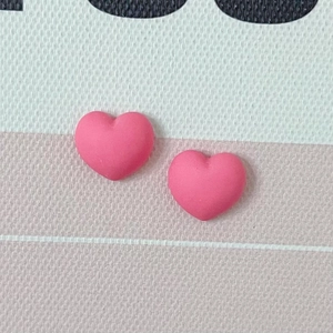 Vue macro de deux breloques cœur roses mates en résine pour bricolage et nail art créatif