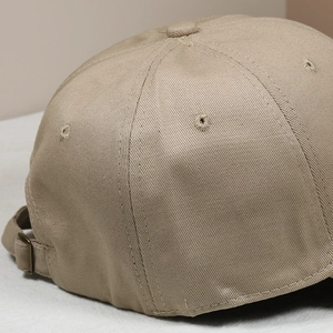Macro shot of khaki baseball cap back showing adjustable metal buckle and stitching
