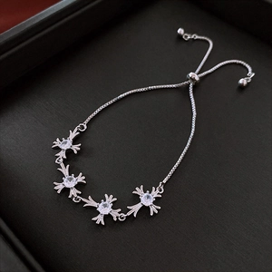 Detail of adjustable silver cross bracelet with sparkling zircons and a bolo clasp