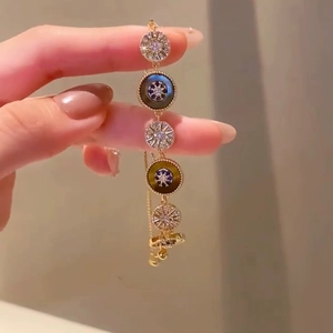 18k gold plated bracelet featuring tiger eye effect charms and sparkling starburst motifs
