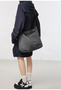 Detail showing high-capacity dark gray nylon messenger bag with smooth adjustable strap