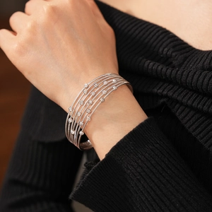 Gros plan d'un bracelet à plusieurs rangs argenté avec des perles facettées sur le poignet