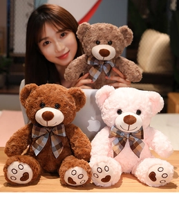 Detail of plush teddy bears with curly fur and classic plaid bows in multiple colors