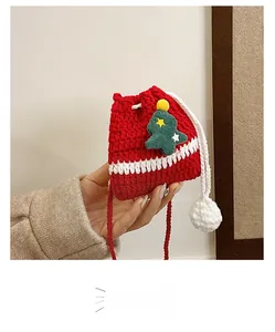 Detail of handmade crochet Christmas drawstring bag featuring a 3D green tree and soft pom-poms