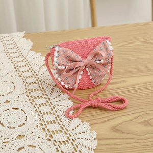 Détail du sac bandoulière en paille rose pour filles avec nœud floral et dentelle