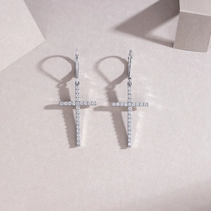 Macro shot of silver cross drop earrings with pavé white zircon and secure lever backs