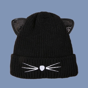 Detail of black knit beanie with cat ears featuring sequin accents and cat face embroidery