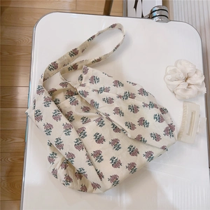 Detailed texture of retro floral cotton fabric on a cream-colored minimalist crossbody bag