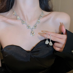 Dettaglio del set collana e orecchini in argento con frange a goccia e cristalli lucidi