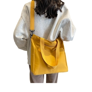 Minimalist yellow canvas tote bag with large capacity shown in a back-view model shot