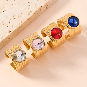 Close-up of gold plated rings with colorful stones and textured band detail