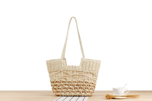 Detail of bohemian woven beach bag featuring intricate hollow out straw craftsmanship