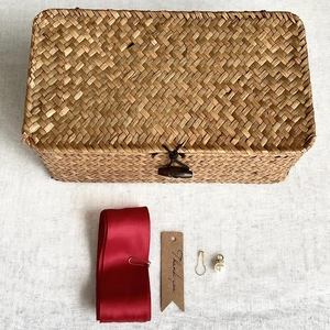Detailed top view of natural seagrass gift box with red ribbon and thank you tag