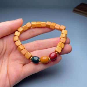 Detail of handmade sandalwood bead bracelet with bamboo lotus style and colorful charms