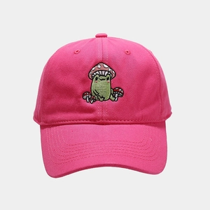 Close-up of a cute green frog with mushroom hat embroidery on a rose pink cotton baseball cap