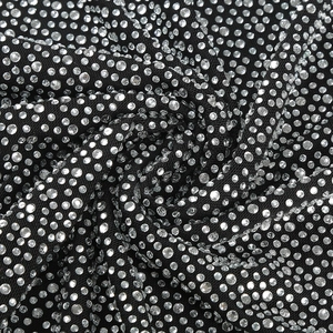 Vue macro détaillée de strass brillants sur le tissu noir d'un tailleur de luxe