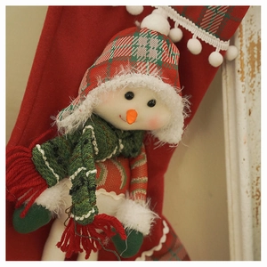 Close-up of plush snowman Christmas stocking with plaid hat and knitted scarf details