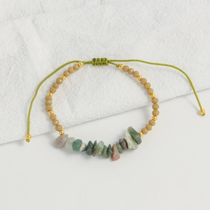 Detailed shot of handmade bohemian bracelet with colorful natural stones and woven cord
