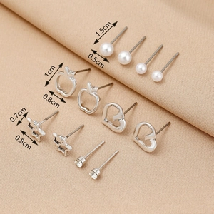 Detail view of 6-pair silver earring set with size dimensions on beige fabric background