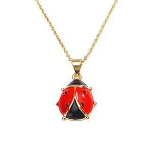 Elegant gold chain necklace with a red ladybug pendant on a clean white background