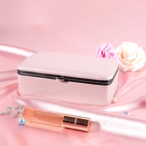 Eleganter rosa Schmuckkoffer aus Leder auf Satin mit Rosenakzenten präsentiert