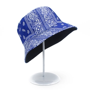 Detail of blue double-sided bucket hat with white paisley pattern on display stand