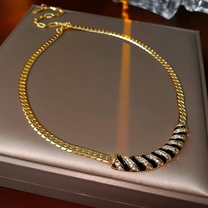 Dettaglio macro della catena cubana placcata oro con smalto nero e strass lucidi