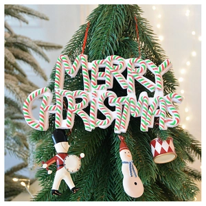 Detail of Merry Christmas letter sign with nutcracker and snowman ornaments on pine tree