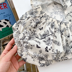 Detail of baby cotton floral bloomers with hand-drawn butterfly and flower print pattern