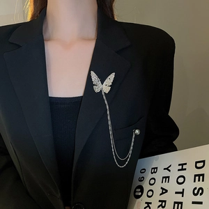 Silver butterfly brooch with pearl tassels pinned to a black suit lapel detail