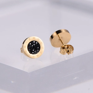 Golden Roman numeral stud earrings with black inlay and diamonds on acrylic stand