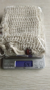 Detail shot of bulk jute soap pouches with wooden beads weighed on a digital scale