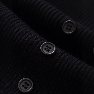 Elegant black ribbed knit midi dress with vertical texture and matching button detail