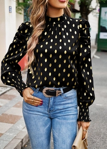 Detail view of black blouse with gold polka dots featuring high neck and puffed sleeves