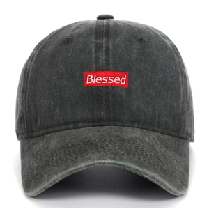 Detail of Blessed embroidery on vintage washed dark grey baseball cap with red patch