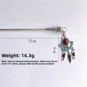 Detailed shot of Chinese style silver hairpin with red gemstone and blue leaf tassels