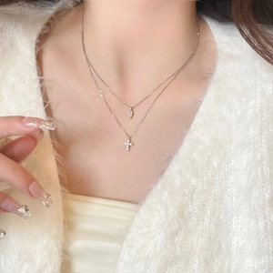 Close-up of double-layer S925 silver necklace with cross and marquise diamond pendant