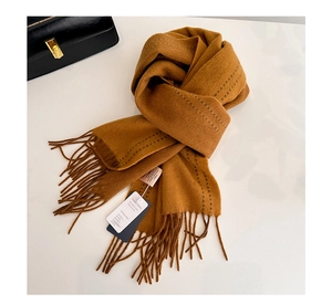 Close-up of caramel 100% acrylic scarf featuring tassel design and visible stitching detail