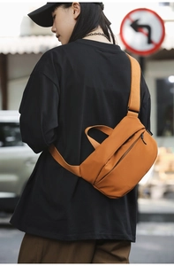 Street style view of a brown nylon crossbody bag with wide strap and minimalist design