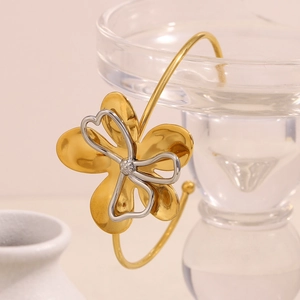 Detail of 18K gold flower bracelet with silver heart cutout on glass edge
