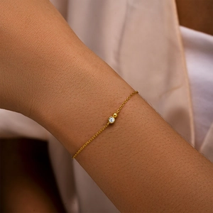 Detailed close-up of a minimalist gold S925 silver bracelet featuring a single cubic zirconia
