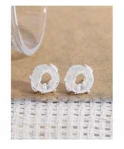 Macro detail of S925 silver lava texture earrings with minimalist organic circular design