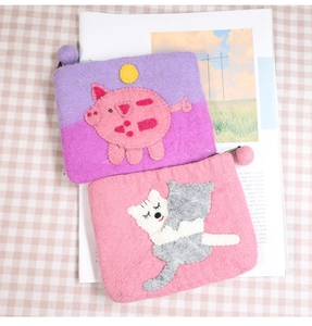 Detailed texture of handmade wool felt coin purses with cute cat and pig animal patterns
