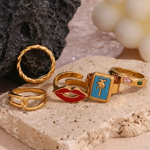 Set of four 18K gold plated stainless steel rings with red lips and gemstone charms