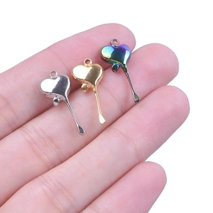 Close-up of stainless steel drip heart pendants in silver gold and gradient colors