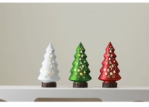 Three illuminated glass Christmas tree ornaments with golden patterns on wood-style bases