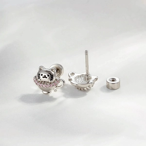 Cute silver kitten in teacup stud earring with pink zircon stones on fabric background