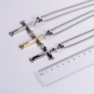 Three minimalist layered cross necklaces in silver, gold, and black with a scale ruler